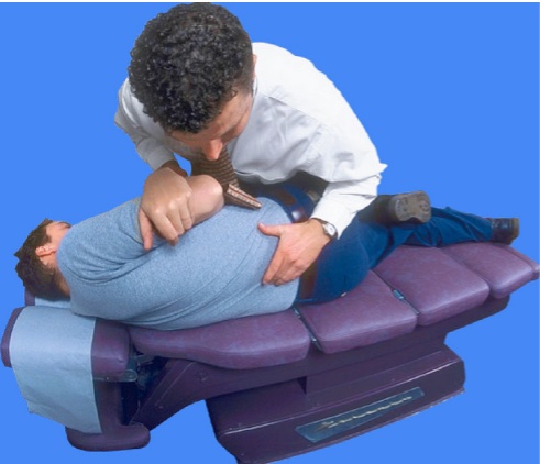 chiropractor adjusting spine in chair